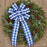 Christmas wreath with blue and white plaid bow on a wooden door