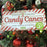 Decorative sign for candy canes on a Christmas tree with ornaments.