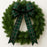 Green wreath with a plaid bow on a white background
