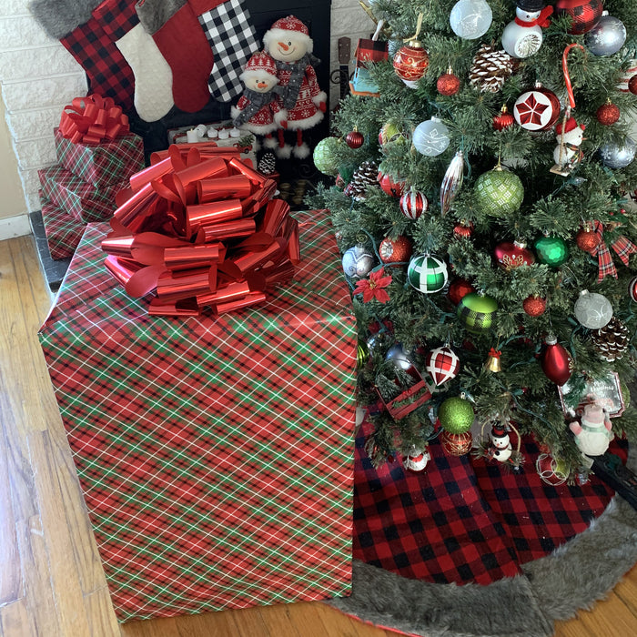 Chrismtas tree on a black red buffalo plaid skirt and a huge gift box with shiny red bow