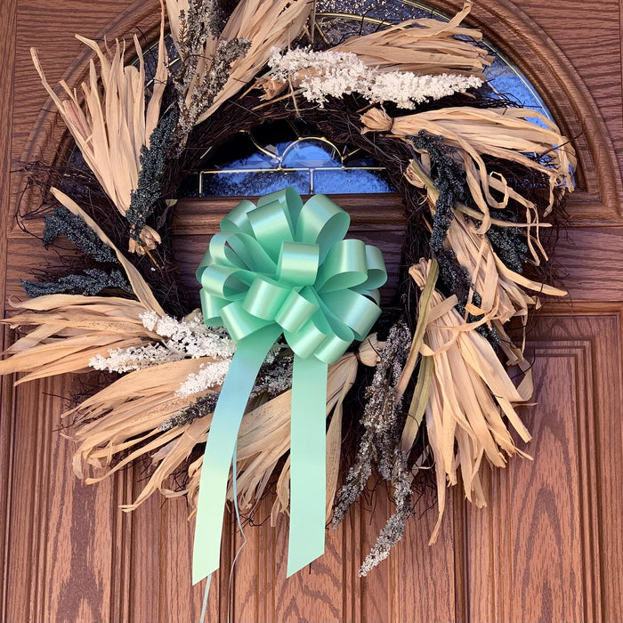 mint pull bows as  a door decoration on a large wreath