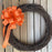 orange bow on a grapevine wreath