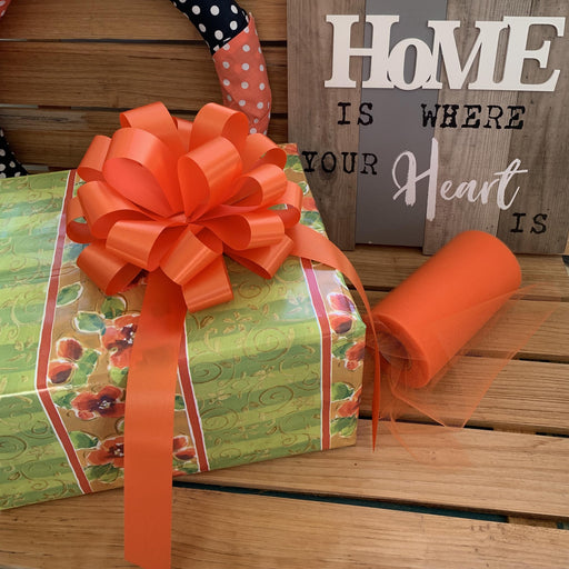 wrap a gift with orange pull bows and tulle