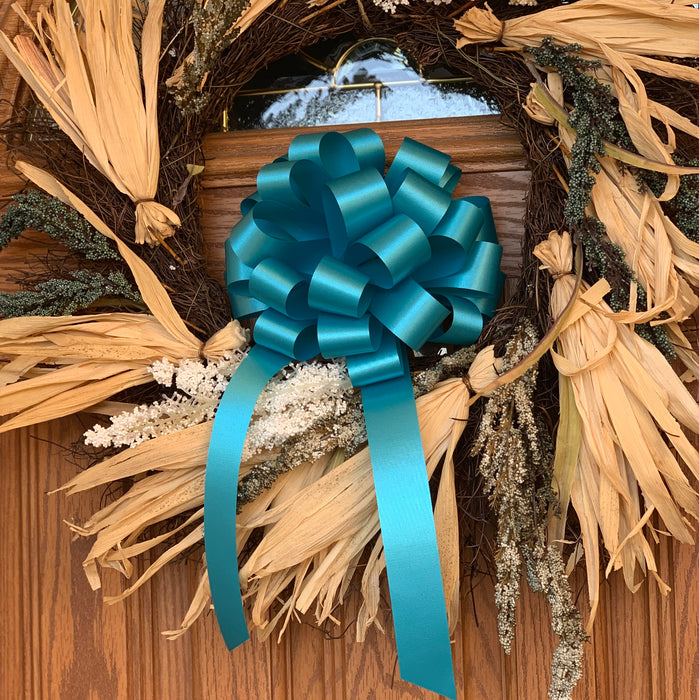 door wreath  decorated with a teal bow